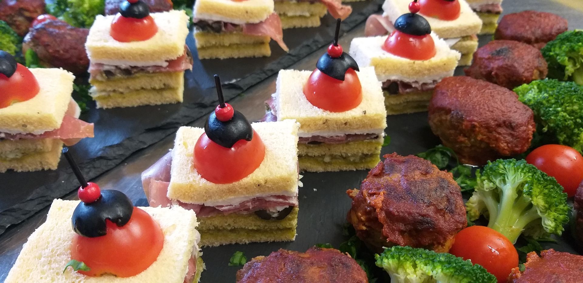 Ein Tisch mit verschiedenen Speisen, darunter Sandwiches und Brokkoli.