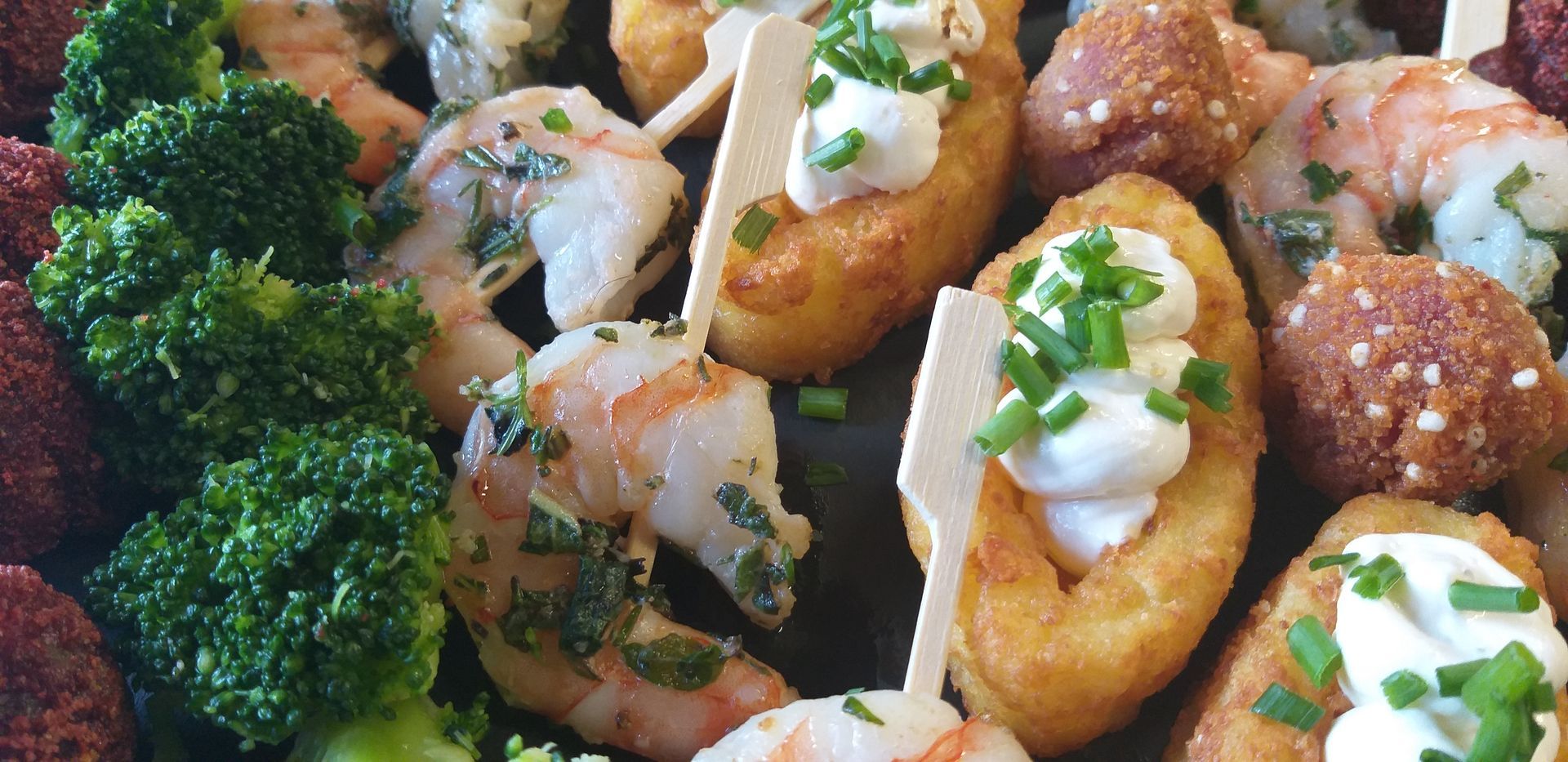 Eine Nahaufnahme eines Tellers mit Garnelen und Brokkoli auf einem Tisch.