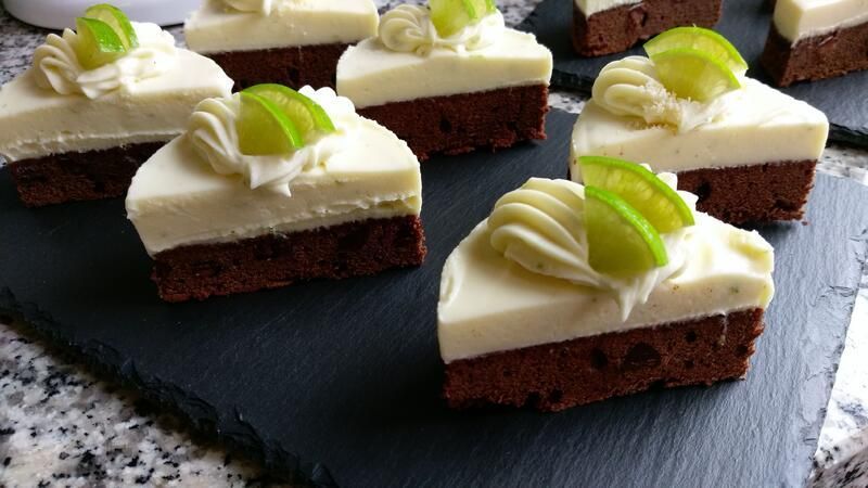 Ein Schneidebrett aus Schiefer, belegt mit Stücken Schokoladenkuchen und weißem Zuckerguss.