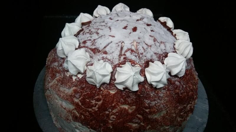 Ein Red-Velvet-Kuchen mit Schlagsahne und Schokoladenraspeln obenauf.