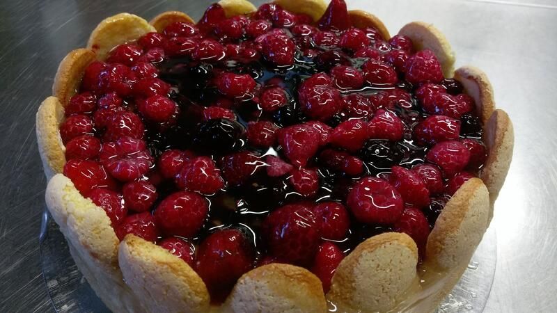 Ein Kuchen mit Kirschen und Brombeeren obendrauf