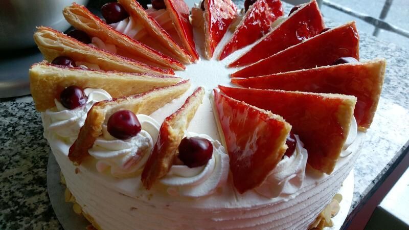 Ein Kuchen mit Erdbeeren und Schlagsahne auf einem Tisch.