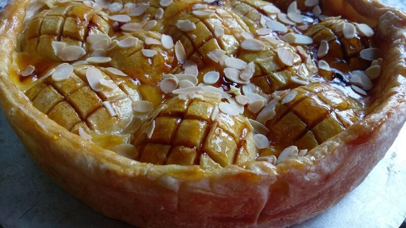 Eine Nahaufnahme eines Kuchens mit Mandeln obenauf auf einem Tisch.