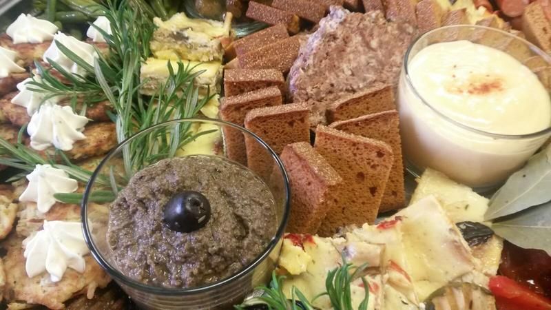 Eine Nahaufnahme eines Tellers mit Essen, Dips und Crackern auf einem Tisch.