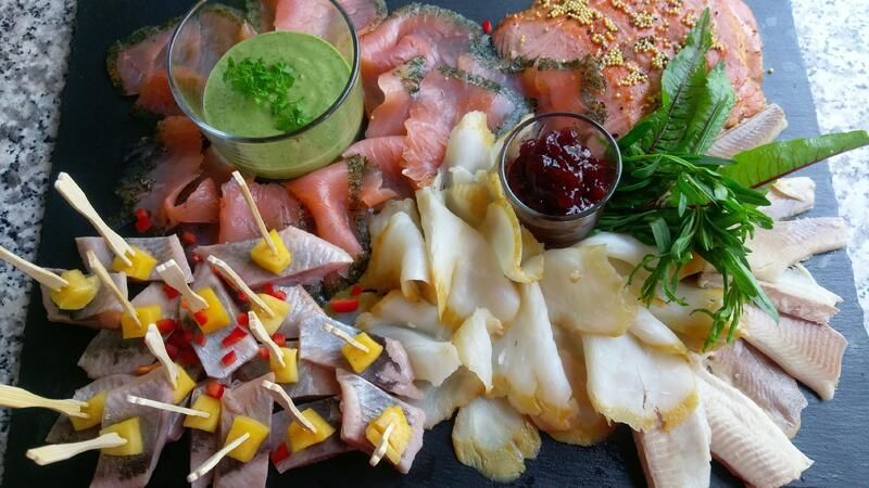 Ein Schneidebrett aus Schiefer, belegt mit verschiedenen Fleisch- und Gemüsesorten.