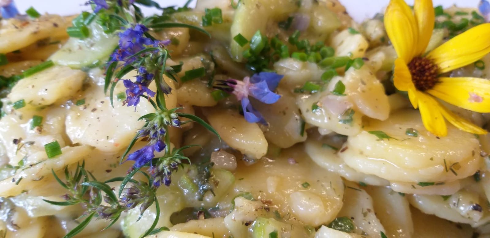 Eine Nahaufnahme eines Tellers mit Essen und Blumen darauf.
