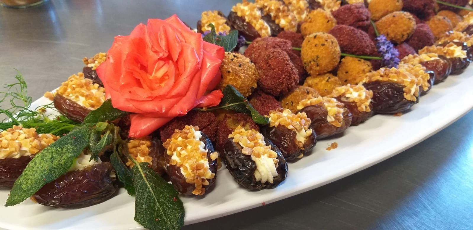Ein Teller mit Essen und einer Rose darauf auf einem Tisch.