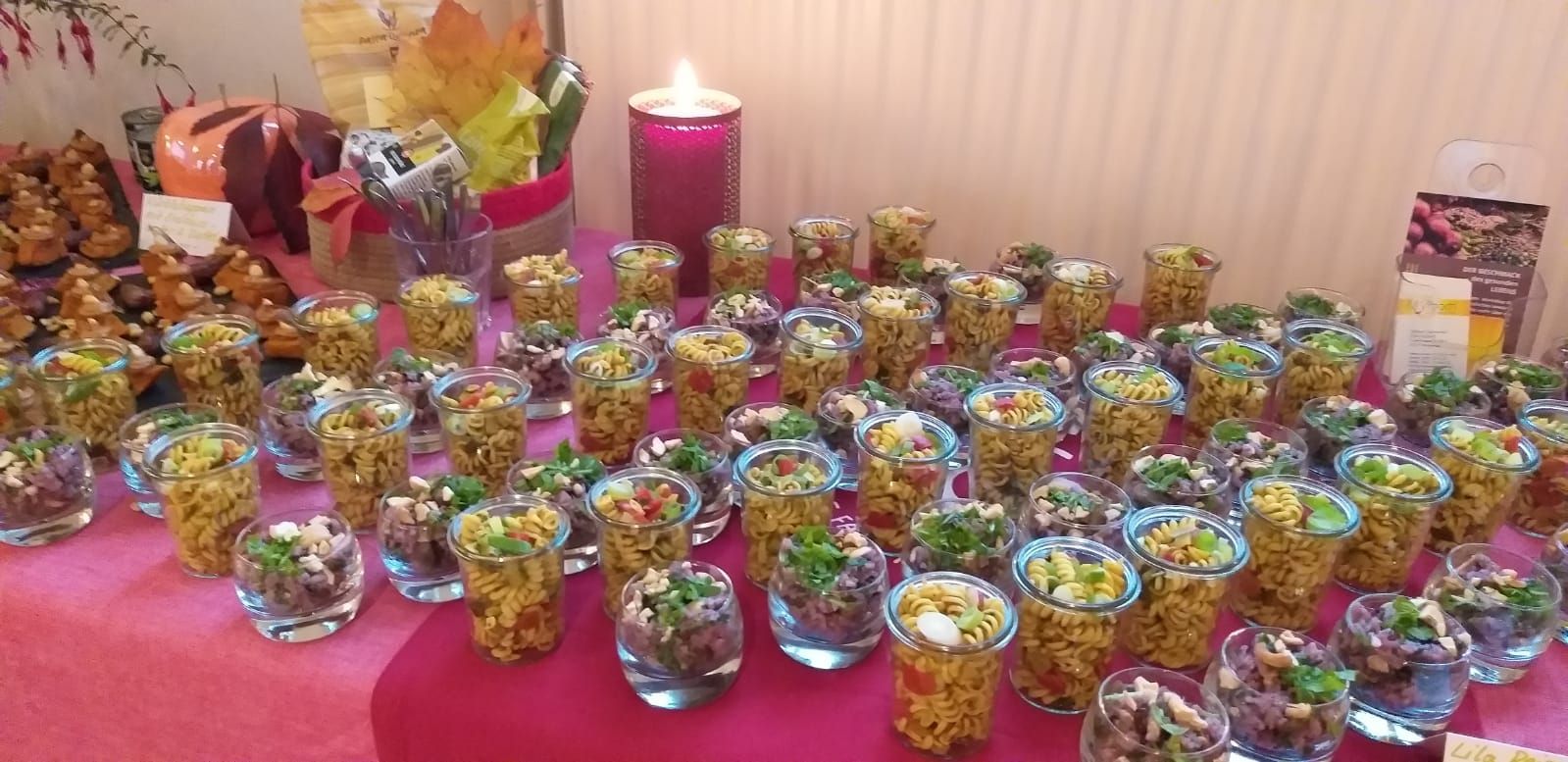 Ein Tisch mit vielen kleinen Tassen mit Essen und einer Kerze.