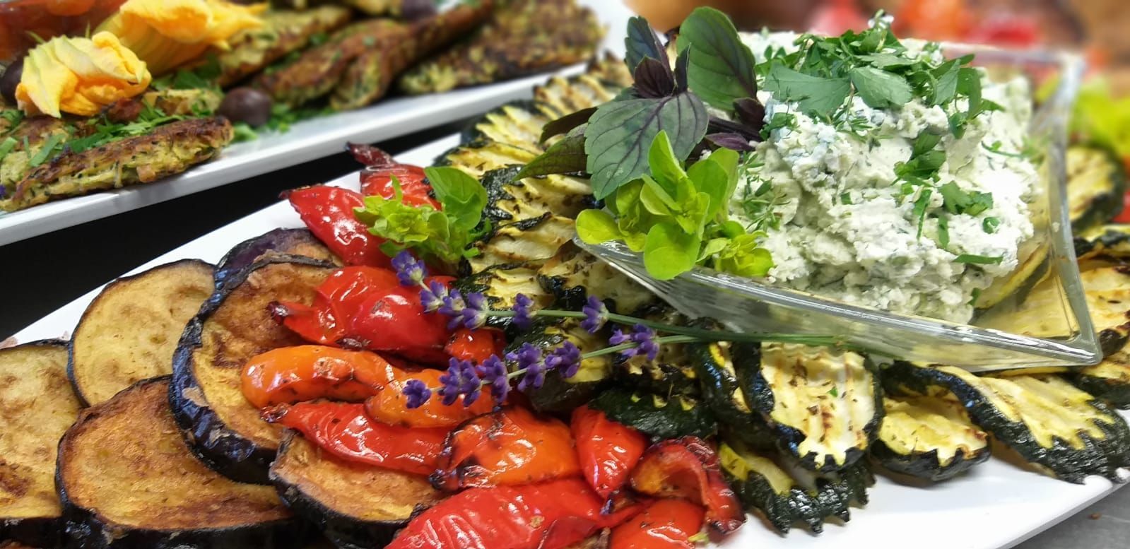 Ein weißer Teller mit verschiedenen Gemüsesorten und einer Schale Dip.