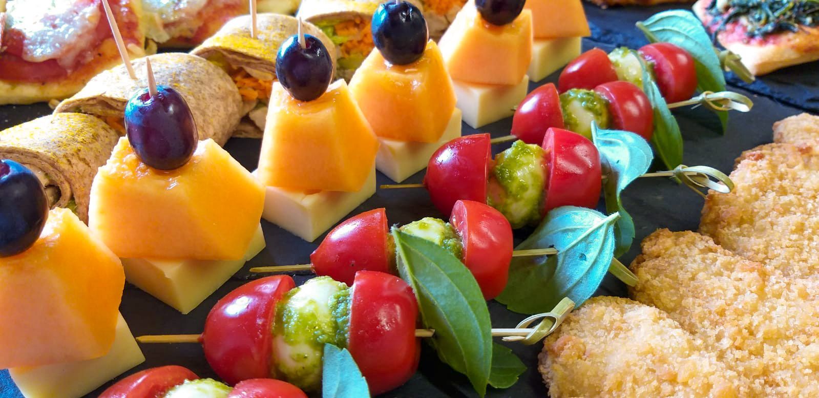 Eine Nahaufnahme eines Tabletts mit Obst und Gemüse auf Spießen.