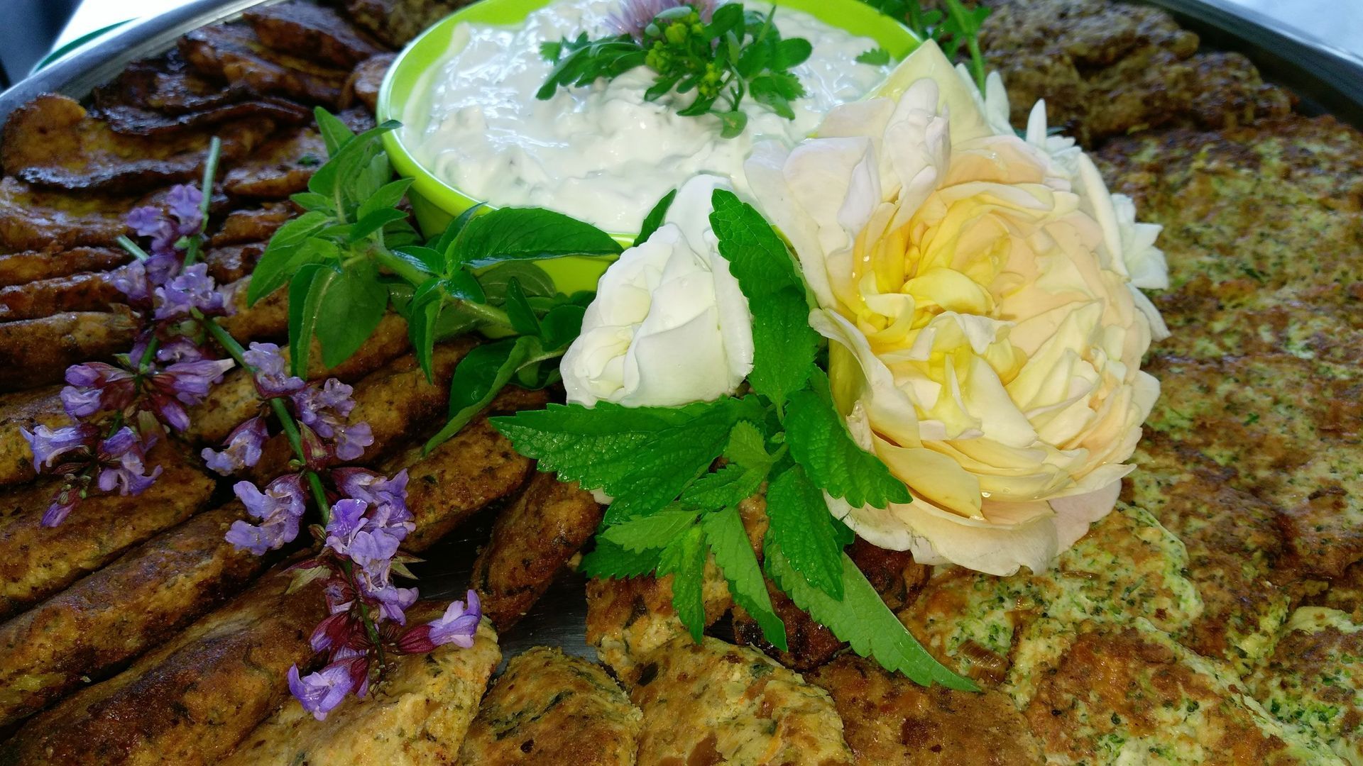 Ein Teller mit Essen und einer Blume darauf.