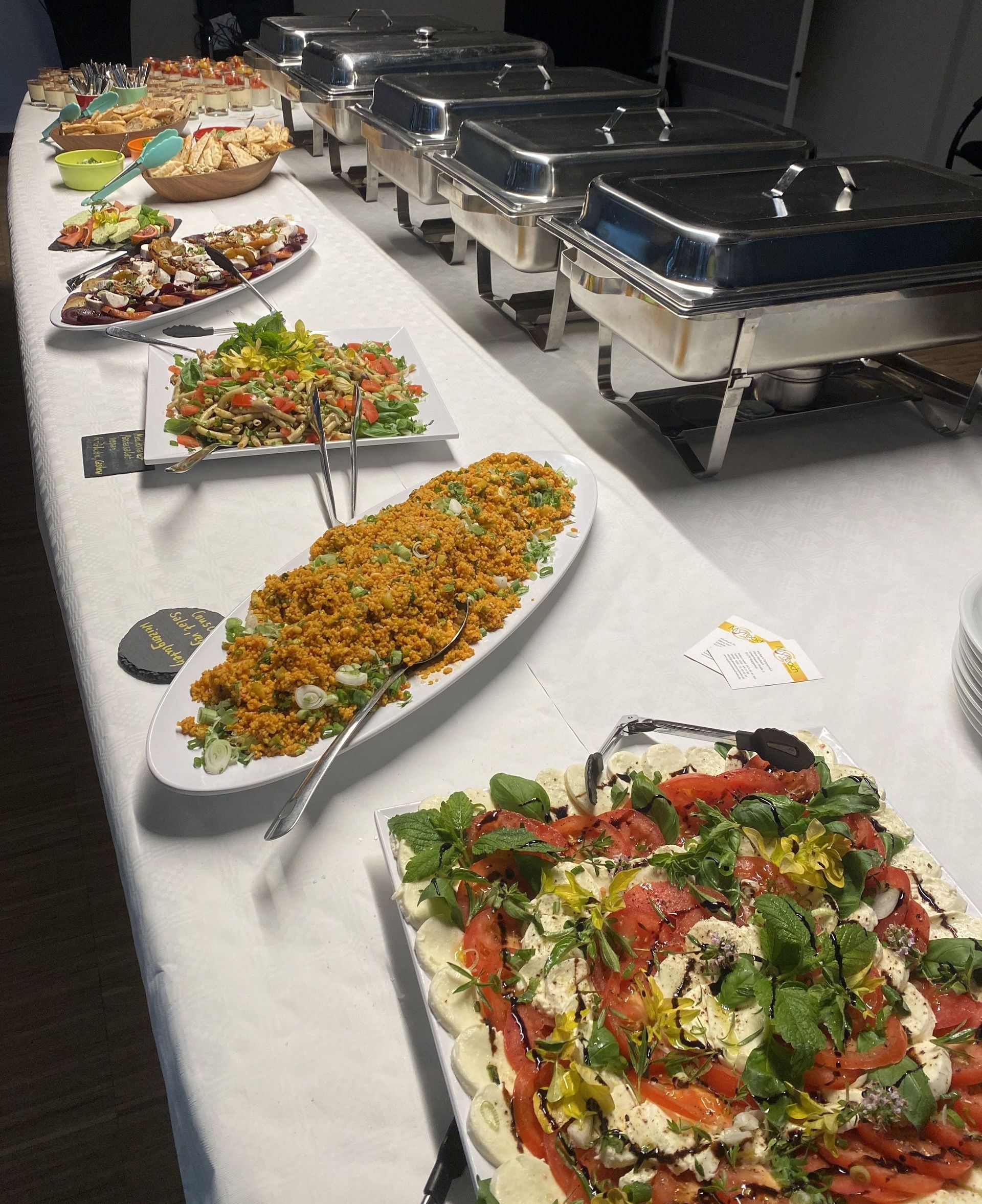 Ein langer Tisch, bedeckt mit Tellern voller Essen und Auflaufformen.