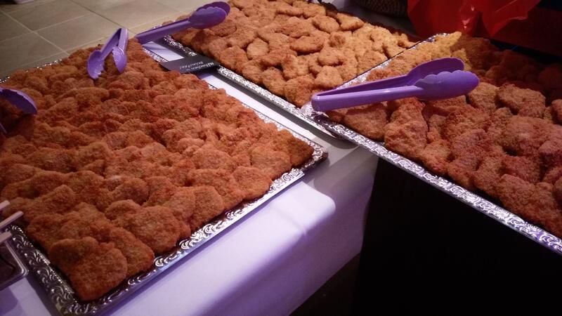 Zwei Tabletts mit frittiertem Essen und Zangen auf einem Tisch.