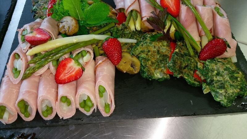 Eine Nahaufnahme eines Tellers mit Erdbeeren und Spargel auf einem Tisch.