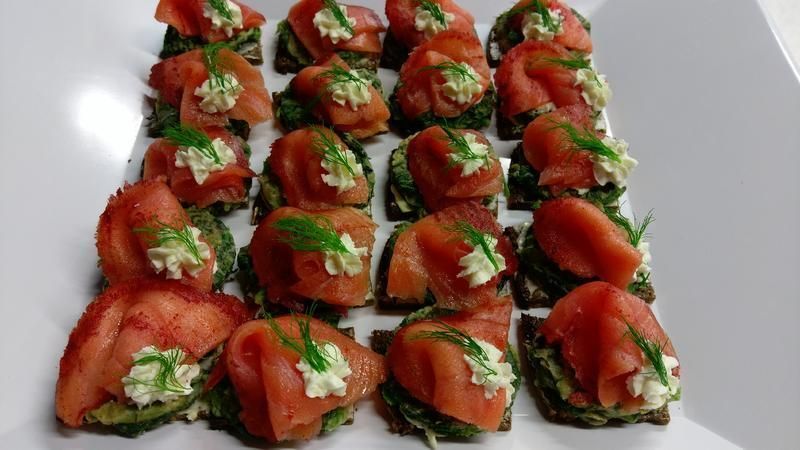 Ein weißer Teller, belegt mit Tomatenscheiben und Avocado.