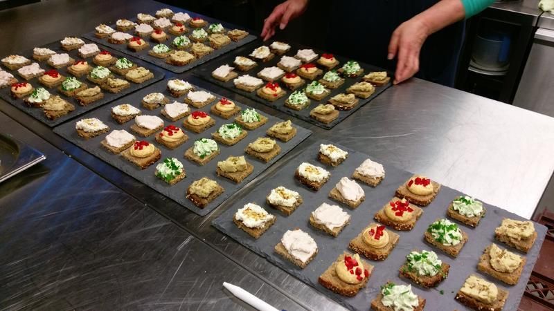 Eine Person bereitet auf einer Theke verschiedene Vorspeisen zu.