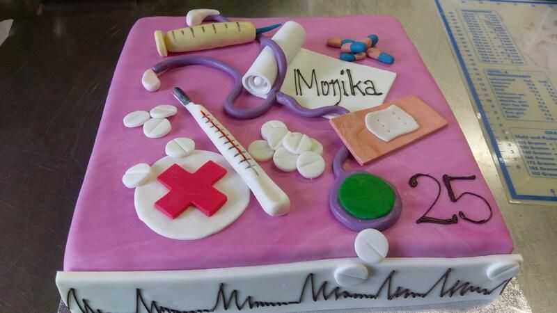 Ein rosa Kuchen mit einem Stethoskop und Pillen darauf