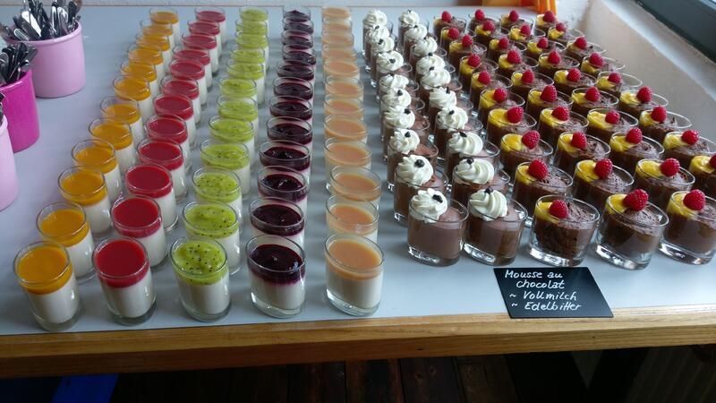 Ein Tisch mit verschiedenen Desserts in Schnapsgläsern.