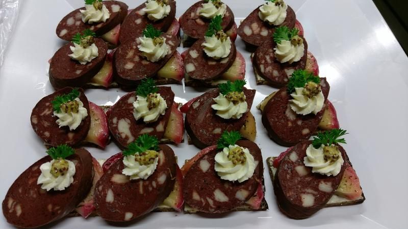 Ein weißer Teller mit Wurstscheiben und Schlagsahne