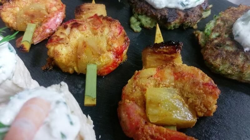 Eine Nahaufnahme eines Tellers mit Garnelen und Ananas am Spieß.