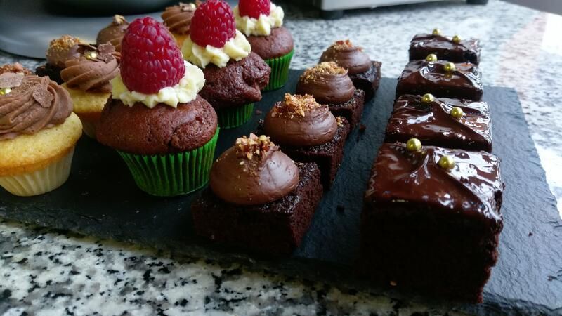 Ein Tablett mit Cupcakes und Brownies auf einem Tisch
