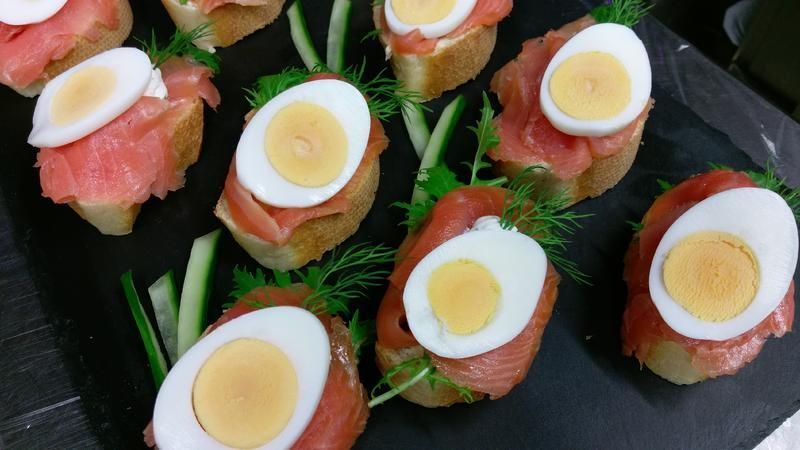 Ein Tablett mit Essen mit Eiern, Lachs und Dill auf einem Tisch.