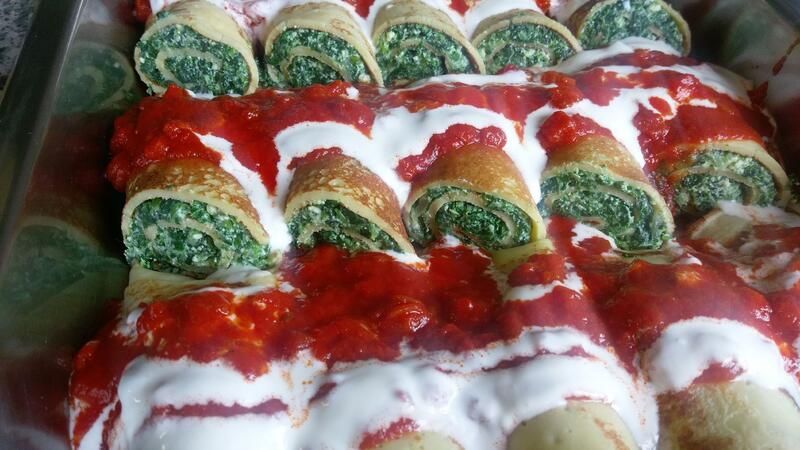 Ein Tablett mit Essen mit Spinat und Tomatensauce darauf