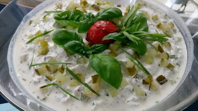 Eine Nahaufnahme einer Schüssel mit Gemüse und einer Tomate darauf.