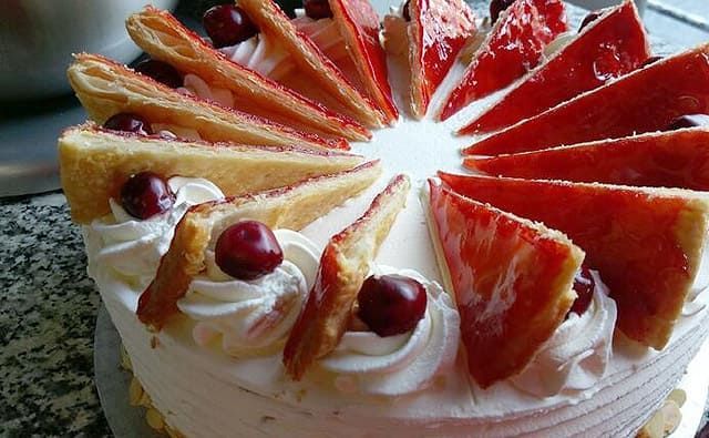 Ein Kuchen mit Erdbeeren und Schlagsahne obenauf
