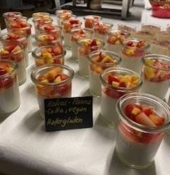 Ein Tisch mit Gläsern voller Obst und Joghurt.