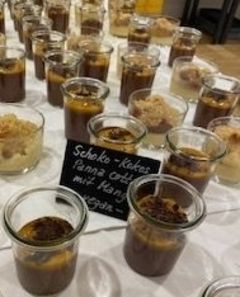 Ein Tisch mit Gläsern voller unterschiedlicher Desserts.