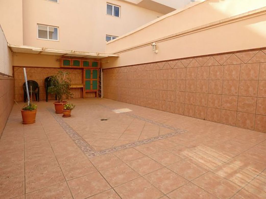 Hay un balcón en la azotea de un edificio con vista al océano.