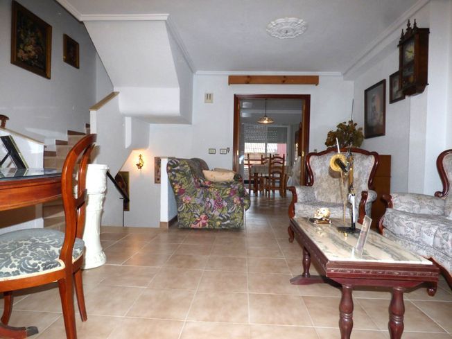 Una sala de estar con muebles y un reloj en la pared.