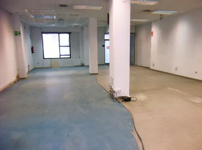 Una habitación vacía con una alfombra azul y paredes blancas.