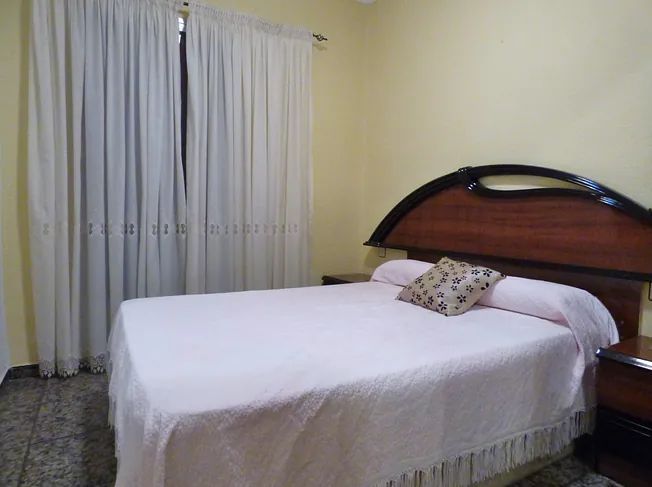 Un dormitorio con una cama y un espejo.