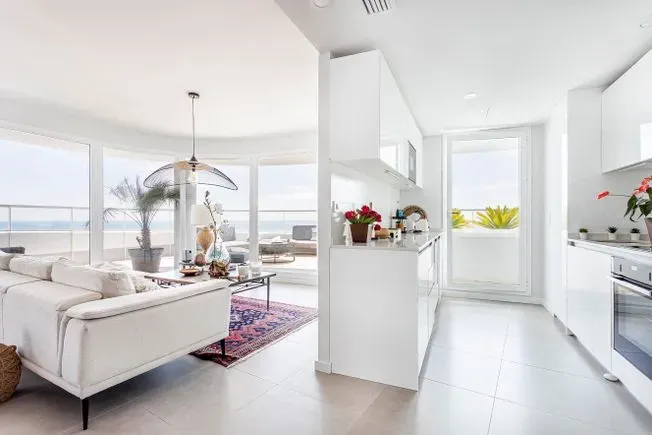 Una sala de estar con una mesa de comedor y sillas y una alfombra.