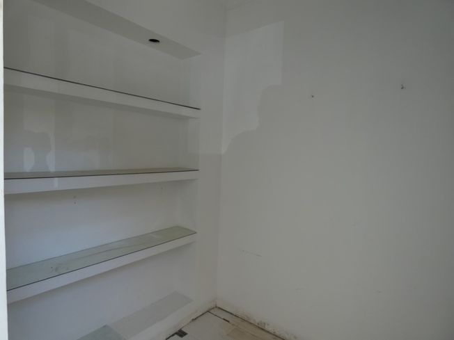 Una habitación vacía con una gran ventana y suelo de baldosas.