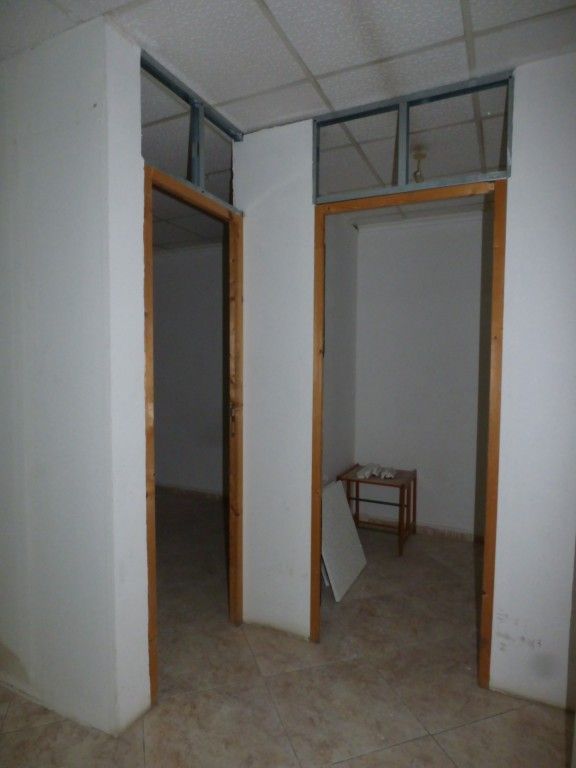 Una habitación vacía con paredes blancas y suelo de cemento.