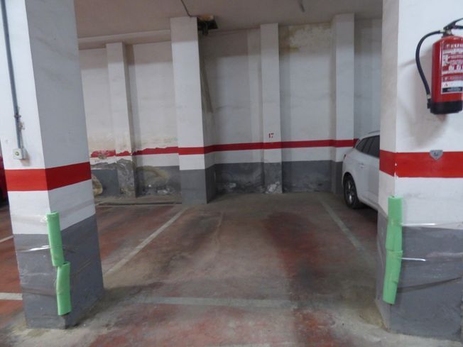 Un coche blanco está aparcado en un aparcamiento.