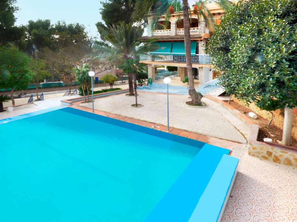 Hay un balcón en la azotea de un edificio con vista al océano.