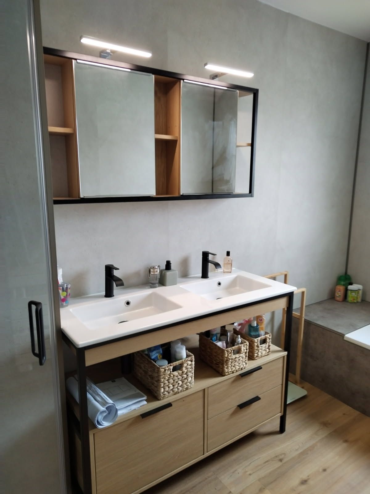 Meuble de salle de bain en bois avec double vasque, un miroir et robinetterie sombre