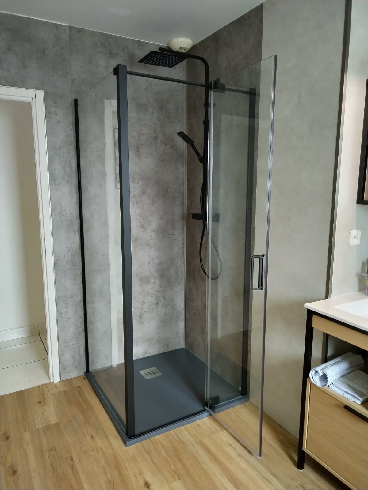 Douche moderne avec parois en verre et robinetterie sombre