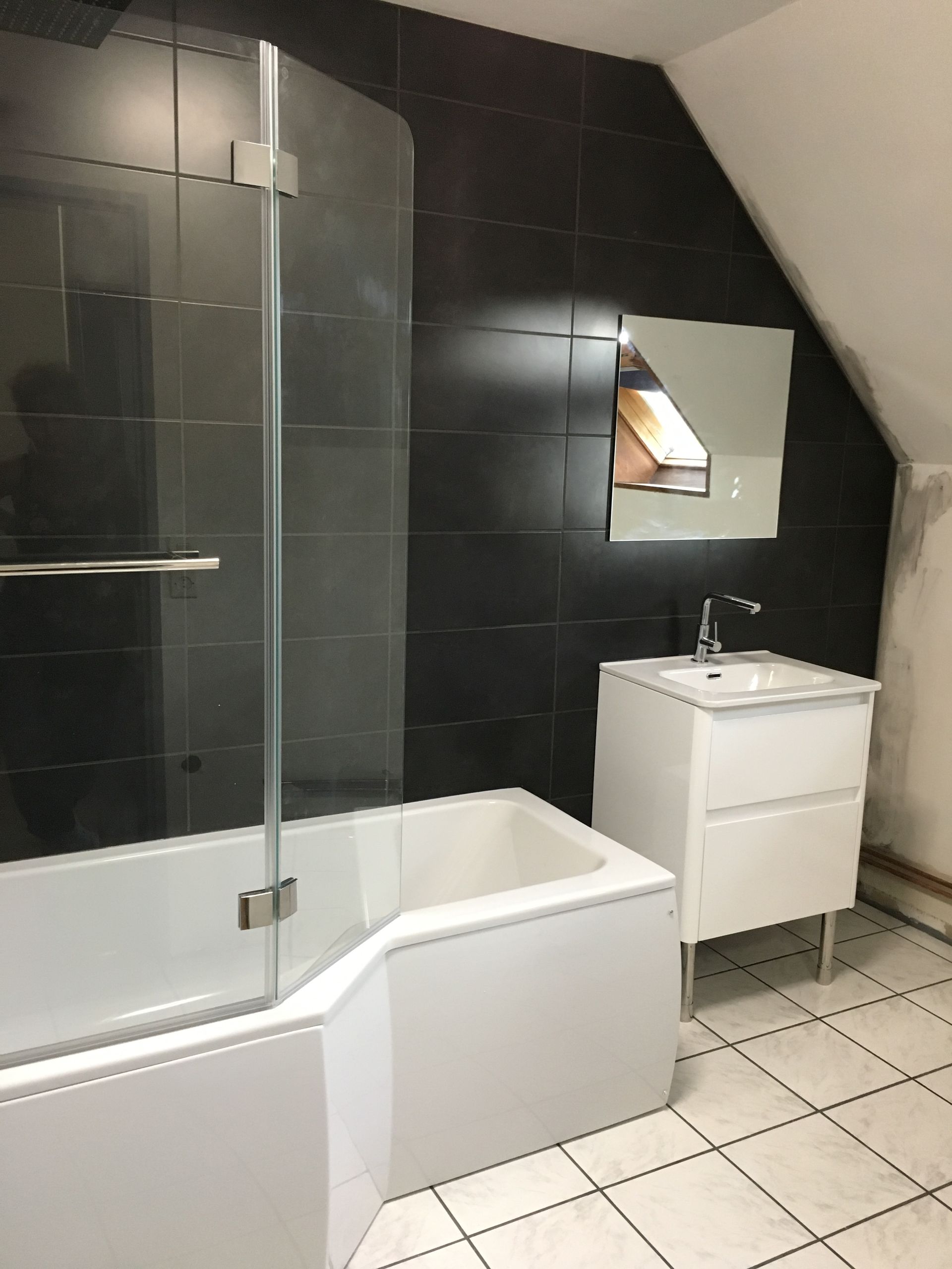 Salle de bains avec mur noir et baignoire