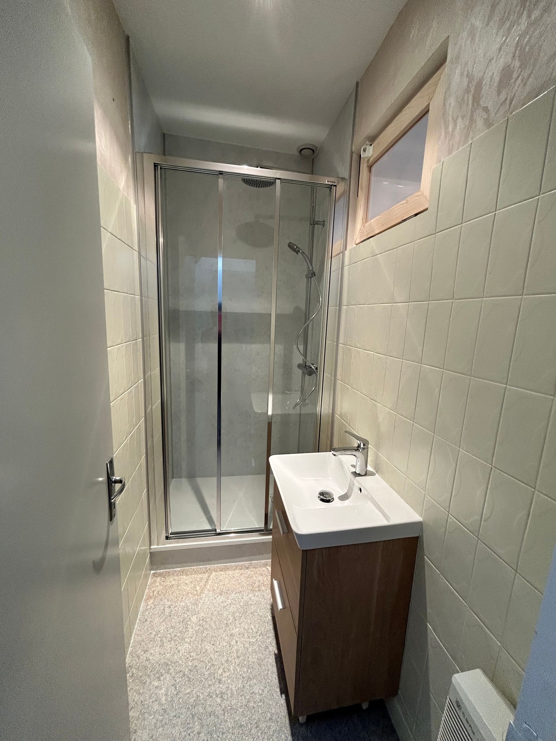 Salle de bains blanche avec douche et vasque encastrée