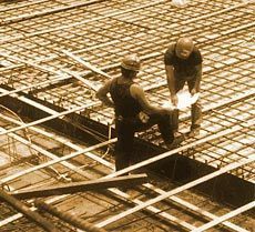 Dos trabajadores de la construcción están trabajando en un piso de concreto.