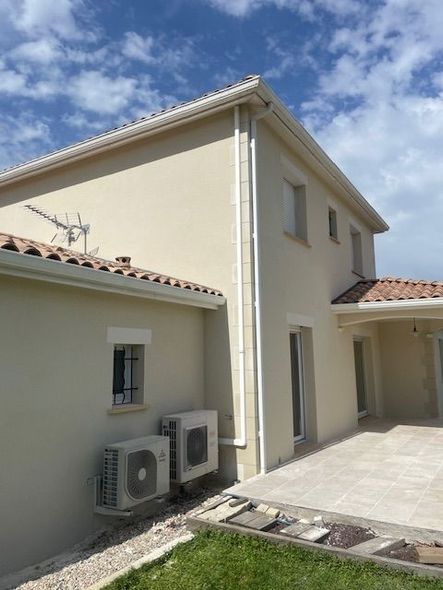 Façade de maison rénovée : encadrements de fenêtres peints en blanc