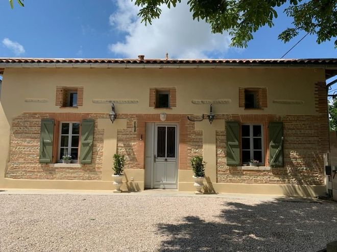 Façade avec crépi rénové et encadrement de fenêtres en briques foraines