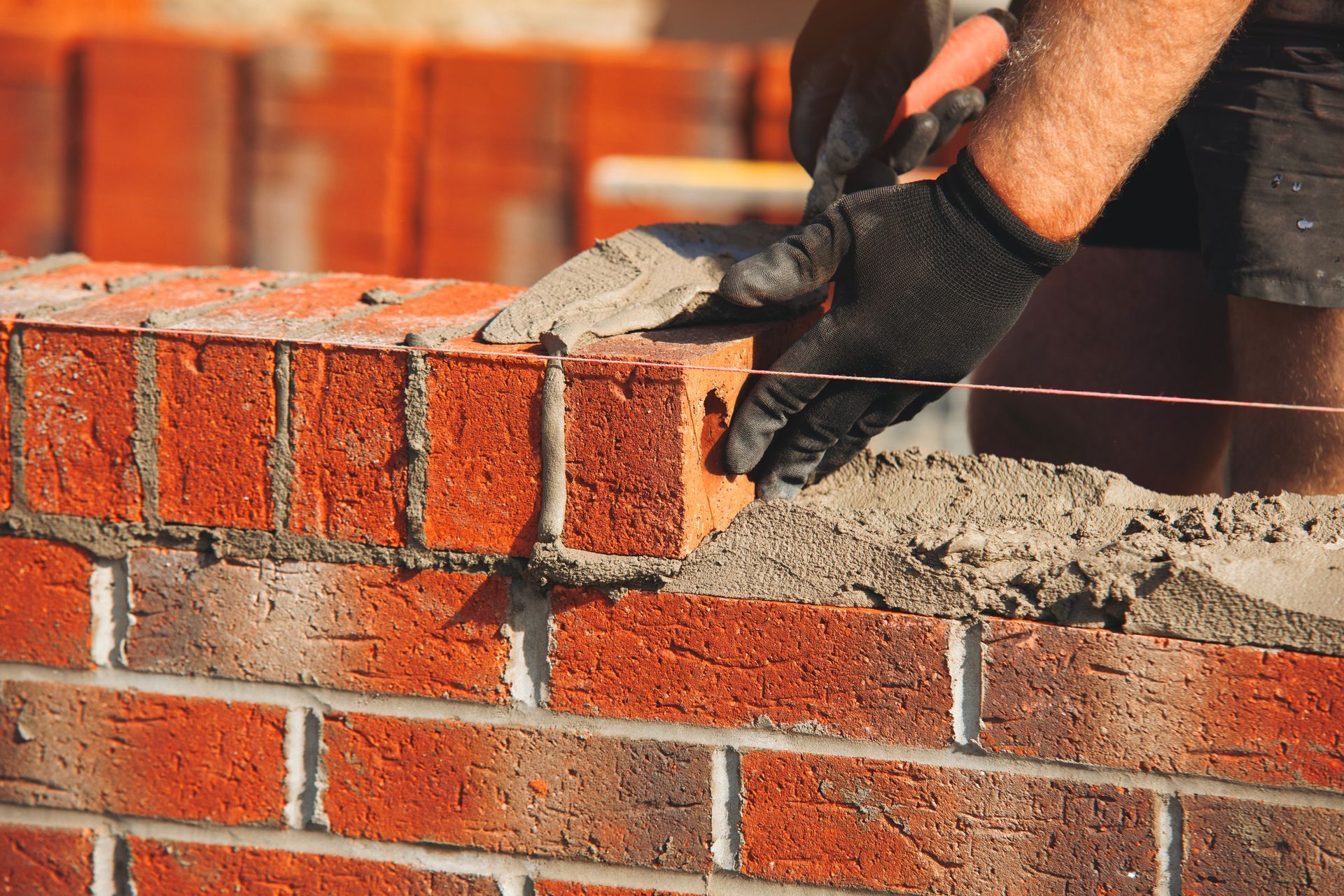 Mains gantées créant un mur de briques