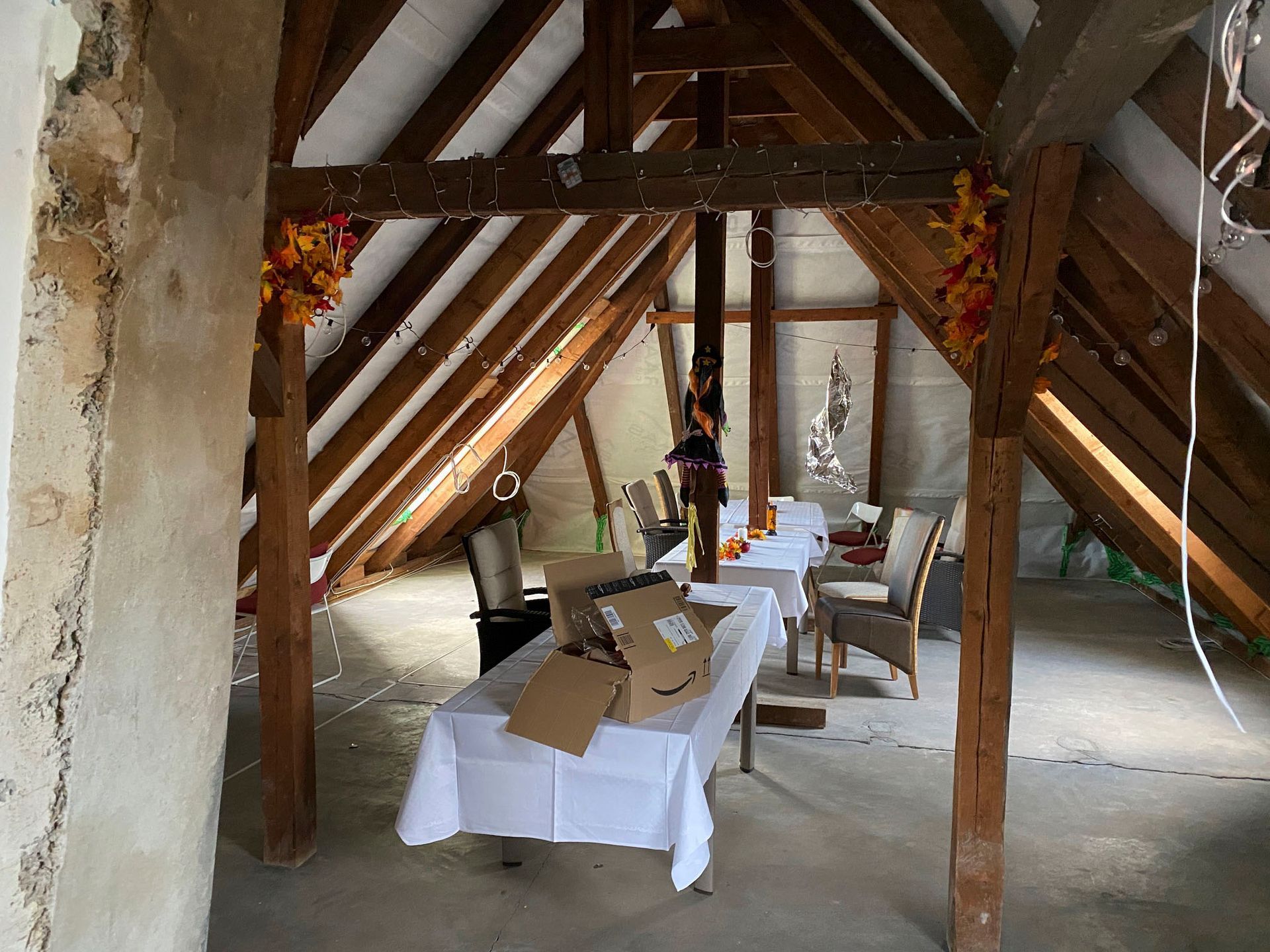 Ein Dachboden mit einem Tisch und Stühlen darin