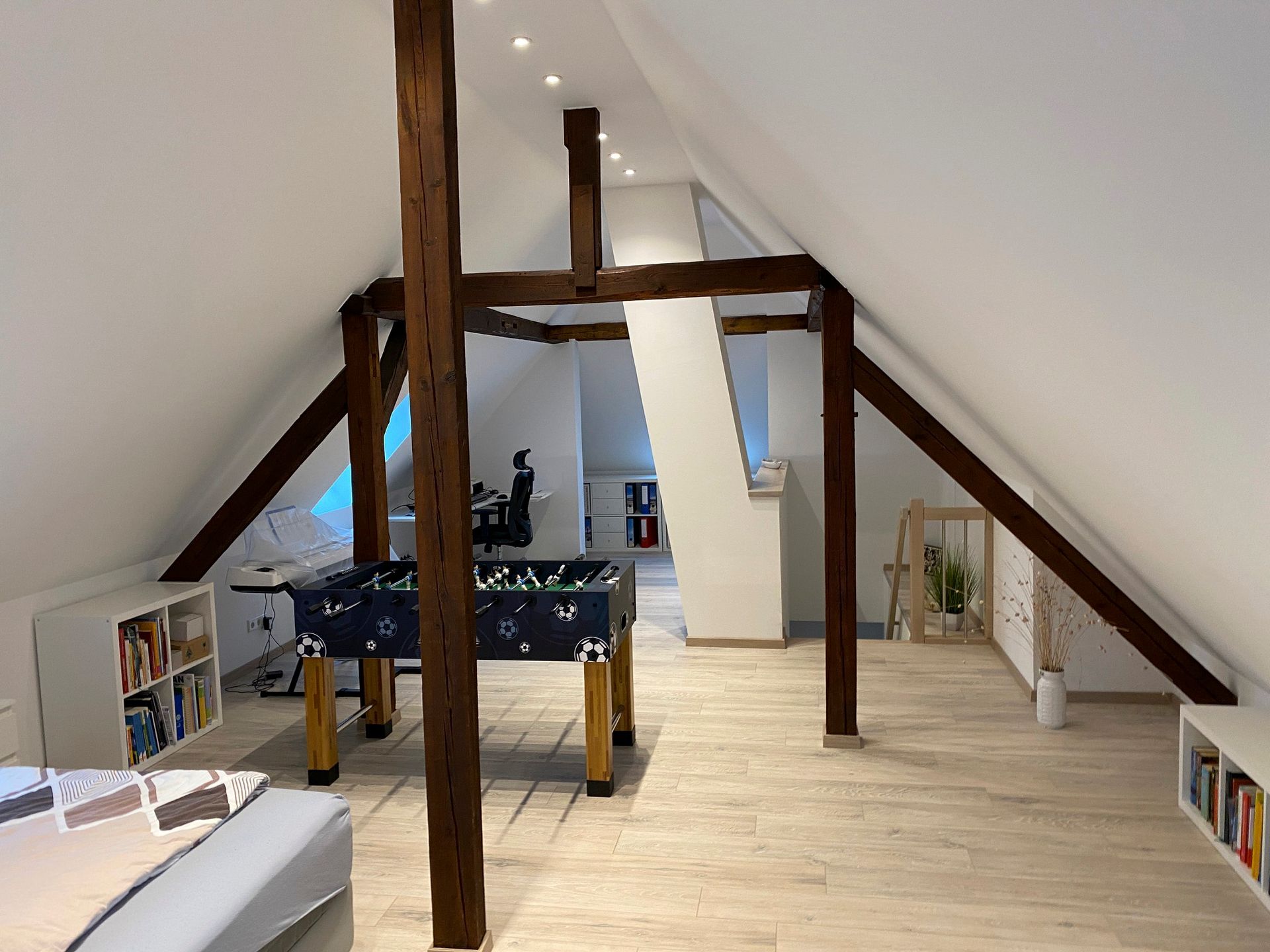 Ein Dachboden mit Holzbalken und einem Tischfußballtisch